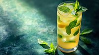 Fresh citrus mojito cocktail garnished with mint leaves on dark green textured background, selective focus. Perfect for restaurant menu and beverage marketing.
