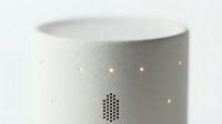 White cylindrical smart speaker with perforated speaker grille and ambient light indicators, isolated on white background for product design and tech mockups.