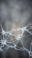 Glowing neural network with interconnected neurons on a dark gray blurred background, depicting brain activity and synaptic connections.