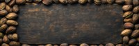 Whole pecans and walnuts arranged as frame border on dark rustic wooden background with copy space in center, top view panoramic food composition.