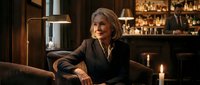 Elegant senior woman relaxing in upscale bar lounge with warm lighting and sophisticated atmosphere for lifestyle and hospitality concepts.