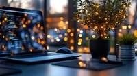 Modern workspace with laptop at dusk, featuring bokeh lights, small potted plants and digital accessories against window backdrop creating cozy atmosphere.