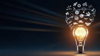 Glowing light bulb with creative icons floating above representing innovation, brainstorming and bright ideas for business solutions and inspiration.
