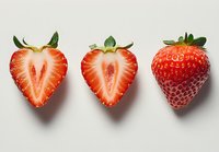 Fresh ripe strawberries on white background - whole berry and halves showing juicy red flesh and texture for food photography and healthy eating concepts.
