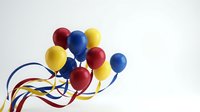 Colorful balloons with ribbons floating against white background for party celebration decoration and festive event design.