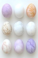 Marble effect Easter eggs in soft pastel colors of purple, white, and peach arranged in neat rows on white background. Delicate crackled patterns create elegant design.