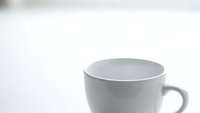 White ceramic coffee mug on clean minimalist background for morning beverage concept and kitchen product photography.