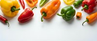 Assorted fresh bell peppers in yellow, red, orange, and green arranged on white background for food and cooking content.
