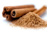 Fresh cinnamon sticks and ground powder on white surface with selective focus, aromatic spice for baking and cooking, natural food ingredient.