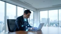 Professional businessman working on laptop with cybersecurity lock icons overlay in modern office, representing data protection and digital security solutions.