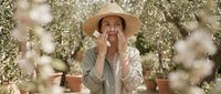 Woman in straw hat among blooming white flowers in greenhouse, gardening and horticulture concept for agricultural and botanical design projects.