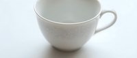 Empty white ceramic cup with handle on white background, suitable for beverage mockups and tableware design projects.