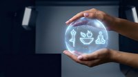 Hand holding glowing holographic sphere with wellness icons including yoga pose, smiling face and plants, representing health, mindfulness and sustainable living concepts.