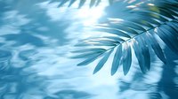 Tropical palm leaves casting shadows in sunlight with dreamy blue tones and soft bokeh effect, creating serene summer atmosphere for wellness and spa designs.