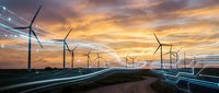 Modern wind turbines generating renewable energy at sunset with digital network connections representing smart grid technology and sustainable power infrastructure.