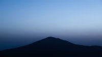 Mountain silhouette against twilight sky with gradient blue tones, suitable for backgrounds, nature themes, and minimalist design projects.