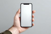 Male hand holding modern smartphone with blank white screen mockup for app presentation and mobile interface design projects.