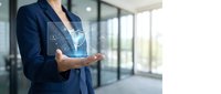 Professional businesswoman presenting digital security shield hologram in modern office environment for cybersecurity and data protection concepts.