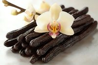 Aromatic vanilla pods with delicate orchid flower on white background. Natural spice ingredient for baking, cooking and flavoring desserts.