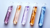 Colorful laboratory test tubes with vibrant liquid chemicals in purple, orange, lavender, amber, and blue, arranged on white background for scientific research.