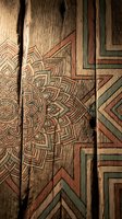Intricate mandala and geometric patterns carved into weathered wooden planks with natural grain texture and rustic charm for bohemian interior design projects.