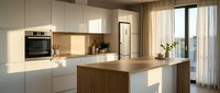 Modern kitchen with white cabinetry, wooden island countertop, and integrated appliances. Bright natural light from large windows illuminates contemporary interior design.