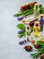 Natural essential oils in glass bottles with fresh herbs, lavender, rosemary, mint and cinnamon sticks for aromatherapy and wellness treatments.