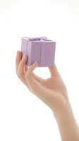 Female hand holding small purple gift box with ribbon bow isolated on white background for holiday celebration and present giving occasions.