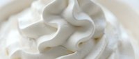 Creamy white whipped cream swirl with smooth texture and flowing curves for dessert and culinary design projects.