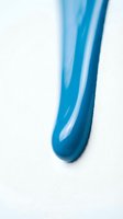 Blue liquid gel cosmetic product smear on white background for skincare beauty and wellness advertising campaigns.