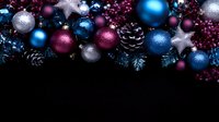 Festive arrangement of blue, burgundy and silver Christmas ornaments, pine cones and berries on dark background, creating elegant holiday border decoration.