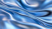 Smooth flowing blue silk fabric with gentle waves and folds creating an elegant abstract background pattern. Soft lighting highlights silky texture and curves.