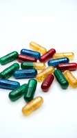 Colorful medicine capsules scattered on white background for healthcare and pharmaceutical industry concepts.