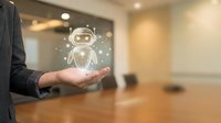 Businesswoman holding glowing robot icon with digital particles in office environment, representing artificial intelligence technology and automation solutions for corporate business applications.