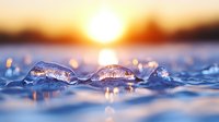 Frozen ice crystals on winter lake surface at golden sunset with sun reflection and bokeh lights creating magical nature macro photography.