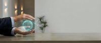 Businessman holding glowing green holographic globe in hands above desk, representing global business, technology innovation, and sustainable corporate growth.