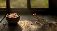 Rustic ceramic bowl with hot chocolate on weathered wooden surface near window, soft natural lighting creates cozy atmosphere with dried flowers.