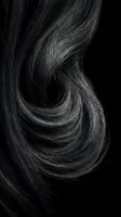 Flowing dark hair strands in elegant spiral curl pattern against black background for beauty and haircare concepts.