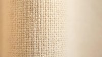 Natural burlap fabric texture with woven fibers in beige and cream tones for rustic design projects and organic material backgrounds.