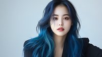 Young Asian woman with vibrant blue ombre hair wearing black against light background, expressing confidence and style. Professional beauty portrait with modern hair coloring.