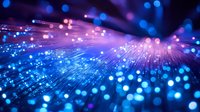 Glowing fiber optic strands emit blue and purple light against dark background, creating luminous bokeh effect and futuristic technology atmosphere.