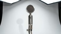 Vintage microphone with metal mesh grille and stand isolated on white background, ready for music production, podcast, or recording studio design projects.