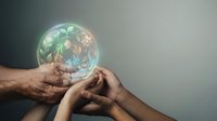 Hands holding glowing sphere with green leaves and recycling symbols representing environmental protection, sustainability and eco-friendly future concepts.