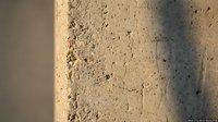 Rough textured concrete wall surface with natural lighting and shadow patterns creating architectural detail for construction and building material concepts.