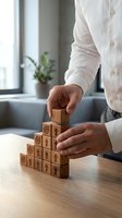 Businessman stacking wooden blocks with arrow and target icons into pyramid shape, symbolizing business growth strategy and goal achievement.