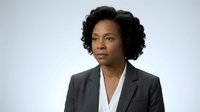 Professional African American businesswoman in dark suit with confident expression against clean white background for corporate presentations.