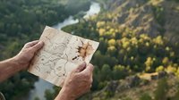 Hiker holding vintage map overlooking forested valley with river, adventure and navigation concept for travel, exploration, and outdoor recreation activities.