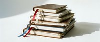 Stack of old worn books with colorful ribbon bookmarks piled on white surface, vintage education and literature concept.