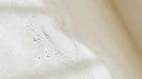 Cream-colored powder or flour with fine texture and subtle shadows, suitable for cosmetics, baking, or skincare product backgrounds.