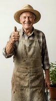 Senior male farmer wearing straw hat and work apron giving thumbs up gesture, isolated on white background for agricultural and gardening industry use.